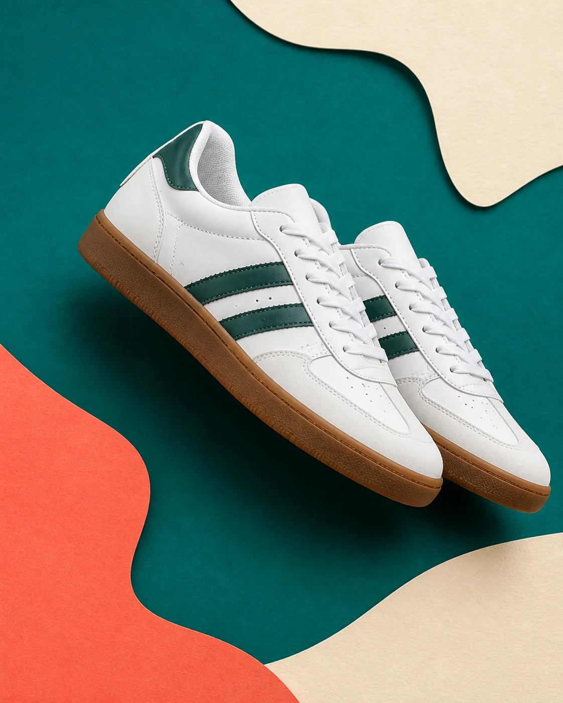 Pair of white trainers on teal and cream paper shapes
